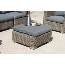 Une table basse avec plateau en verre transparent et un coussin.