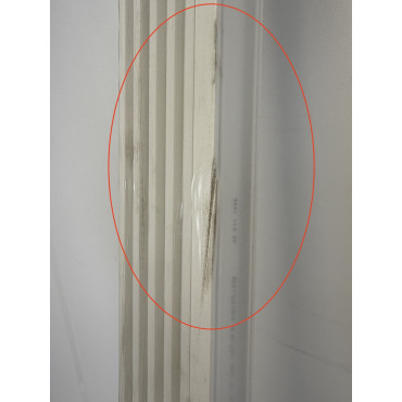 Gros plan sur le défaut superficiel présent sur une plinthe Quick-Step blanche