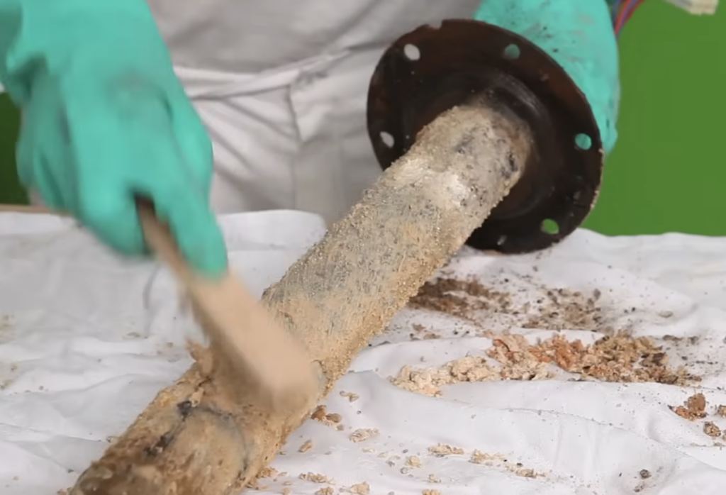 Nettoyage de la résistance d’un chauffe-eau Atlantic couverte de calcaire lors du détartrage